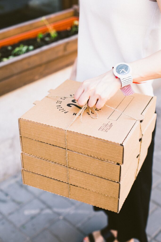 Person in White Dress Shirt Holding Brown Cardboard Box